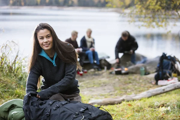 Ung kvinna uppackning ryggsäck på campingplats — Stockfoto