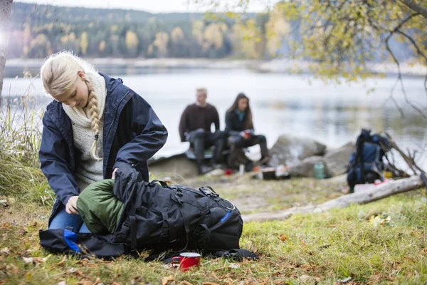 Mujer joven desembalaje mochila en el camping —  Fotos de Stock