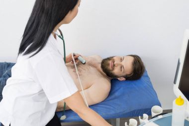 Doktor ultrason makinesi ile erkek hasta incelenmesi