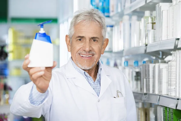 Химик держит мыльный диспенсер в аптеке — стоковое фото