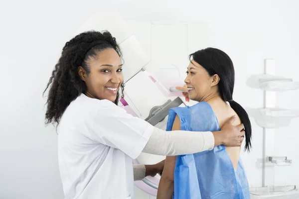 Γιατρός θηλυκό βοηθώντας γυναίκα που υποβάλλονται σε μαστογραφία ακτινοσκοπικό έλεγχο — Φωτογραφία Αρχείου