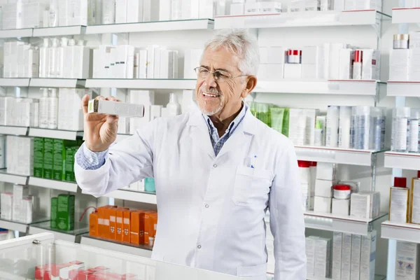 Senior-Apotheker zeigt Medikamentenbox am Tresen — Stockfoto