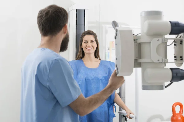 Radiologista ajustando a máquina de raios-X em paciente feminina no hospita — Fotografia de Stock