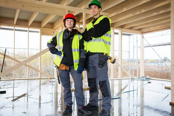 Confident Female Carpenter Standing By Colleague At Construction — Stock Photo, Image