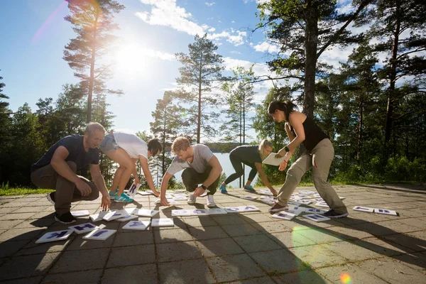 Pleine longueur de collègues de résoudre des mots croisés Puzzle dans la forêt — Photo