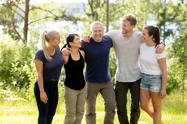 Mann steht mit Waffen um Freunde im Wald — Stockfoto