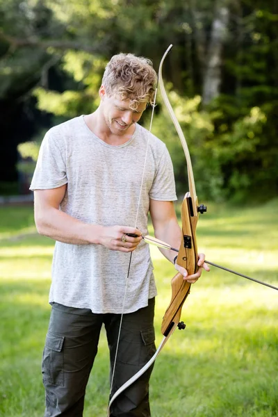 Pewność Archer mężczyzna trzyma łuk i strzały w lesie — Zdjęcie stockowe