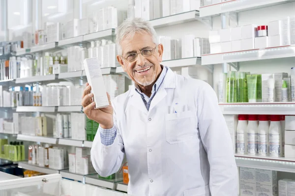 Jistý lékárník drží medicína Box v lékárně — Stock fotografie