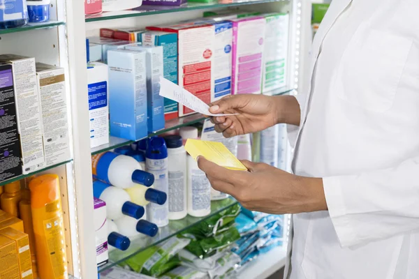 Apotheker hält Quittung und Rezept in Apotheke — Stockfoto