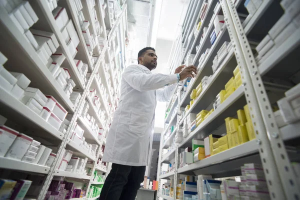 Joven Hombre Químico Arreglando Productos En Estantes En Farmacia — Foto de Stock