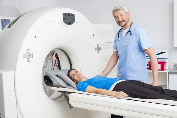 Läkare står med patienten liggande på Mri maskin — Stockfoto