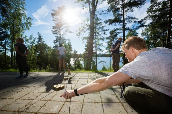 Чоловік вибирає дерев'яний блок з мотузкою під час гри з друзями — стокове фото