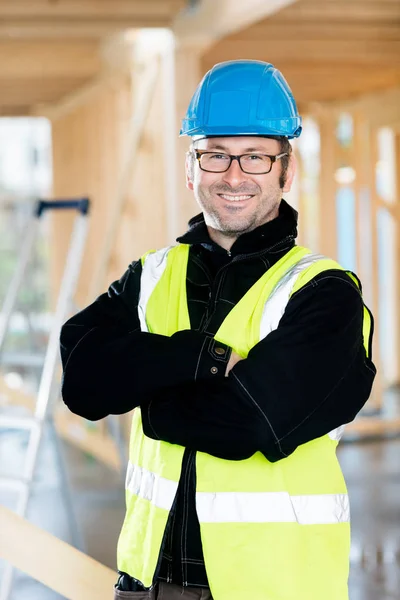 Bras debout charpentier mature croisés sur le chantier de construction — Photo