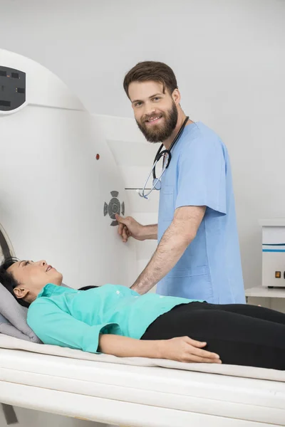 Médico jovem prestes a iniciar a tomografia computadorizada no paciente feminino — Fotografia de Stock