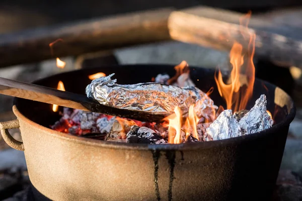 Їжа загорнута в фольгу готується на вогнепальній — стокове фото