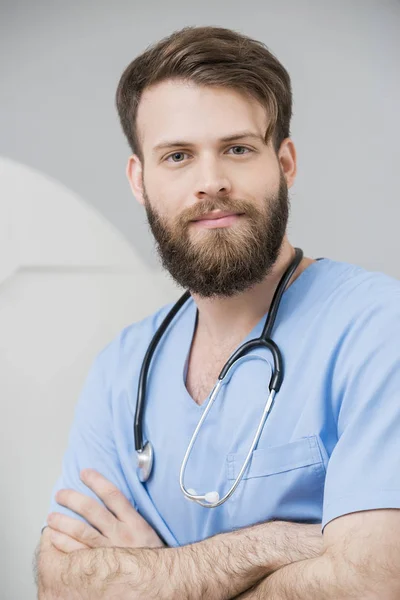 Lekarz mężczyzna stojący z założonymi w sali egzaminacyjnej — Zdjęcie stockowe
