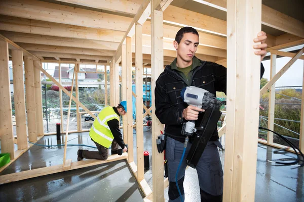 Carpinteros de perforación de madera en el sitio de construcción —  Fotos de Stock