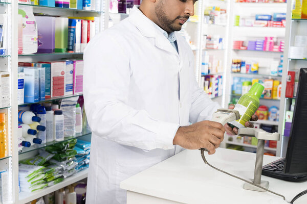 Chemist Scanning Barcode Of Product At Checkout Counter