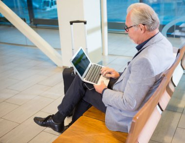 Laptop alan bekleyen havaalanında kullanarak iş adamı