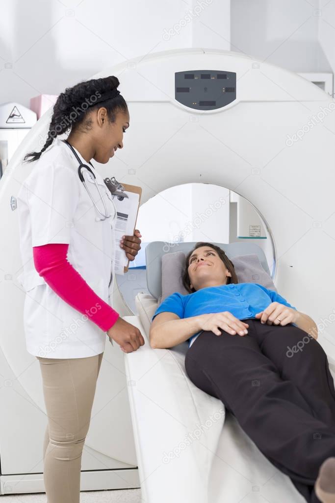 Female Radiologist Looking At Patient Undergoing MRI Scan