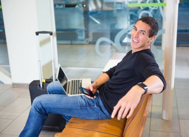 Neşeli adam cep telefonu ve Laptop havaalanında