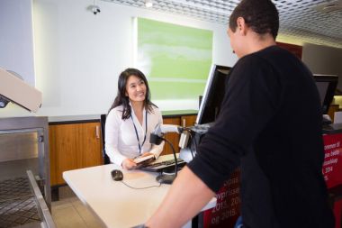 Erkek yolcu havaalanında bakarak pasaportu ile personel