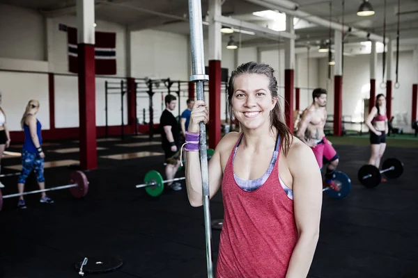 Kvinna med skivstång Pole i Gym — Stockfoto