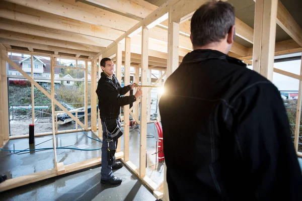 Professionella snickare mäta träpelare på plats — Stockfoto