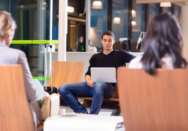 Jonge Man met behulp van Laptop op luchthaven Lobby wachten — Stockfoto