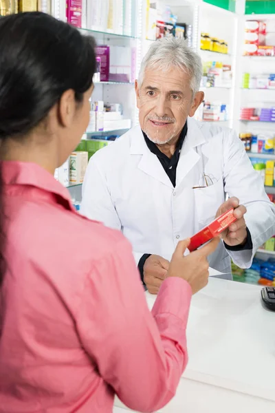 Farmacista Mostrando il prodotto al cliente femminile — Foto Stock