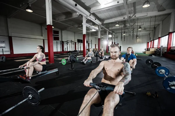 Muskulöser Mann trainiert auf Rudergerät — Stockfoto