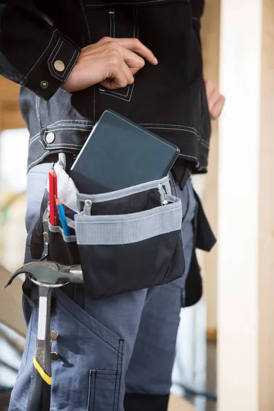 Midsection Of Carpenter With Digital Tablet And Tools In Bag — Stock Photo, Image