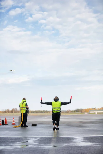 Marshaller Holding Signal Wands while Standing By Colleague On R — стоковое фото