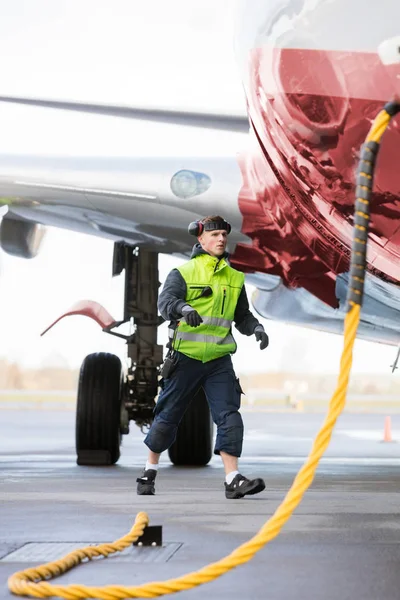 Член екіпажу, який ходить літаком, заряджається на злітному — стокове фото