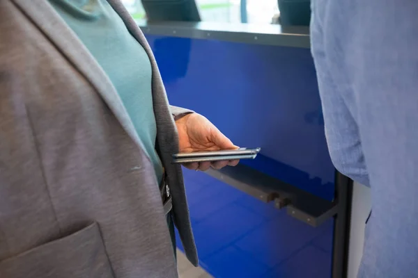 Деловая женщина с мобильным телефоном и паспортом на стойке регистрации аэропорта — стоковое фото