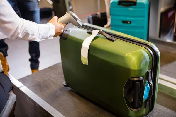 Женщина сканирования тег на багаж при регистрации в аэропорту — стоковое фото