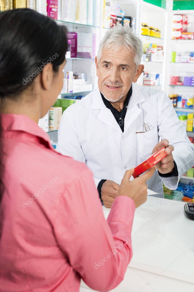 Pharmacist Showing Product To Female Customer