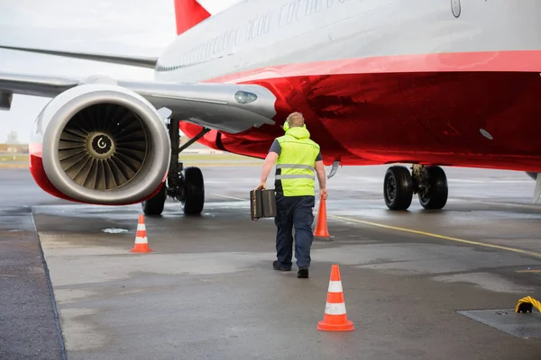 Werknemer uitvoering Traffic Cone en Chocks per vliegtuig op baan — Stockfoto
