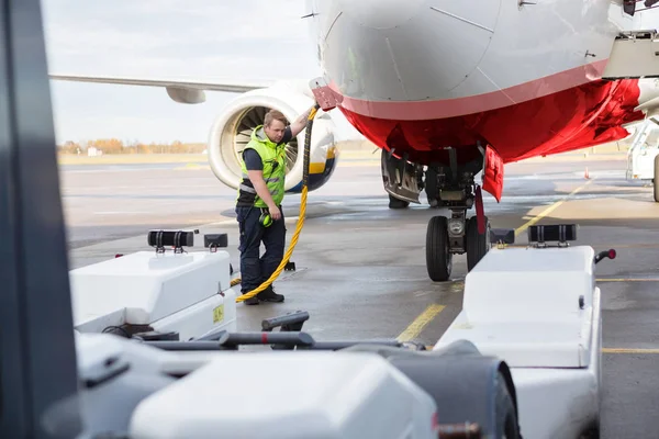Membro da tripulação adulta média que carrega o avião na pista — Fotografia de Stock