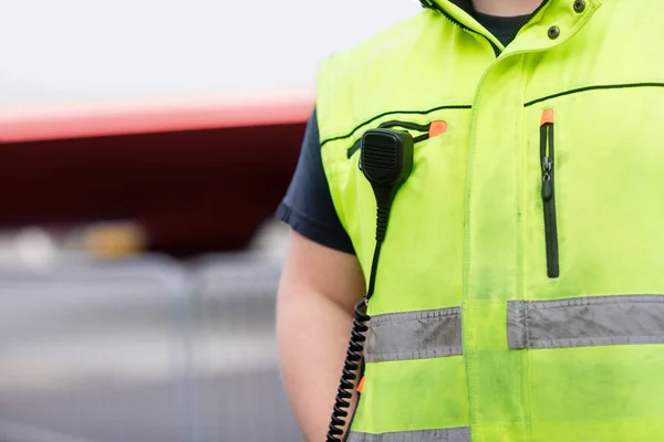 Lavoratore con microfono attaccato sulla giacca riflettente in aeroporto — Foto Stock