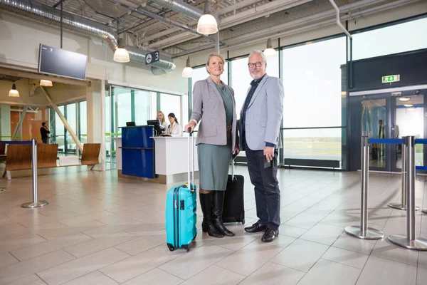 Pareja de negocios mayores sonriendo con recepcionistas trabajando en el aire — Foto de Stock