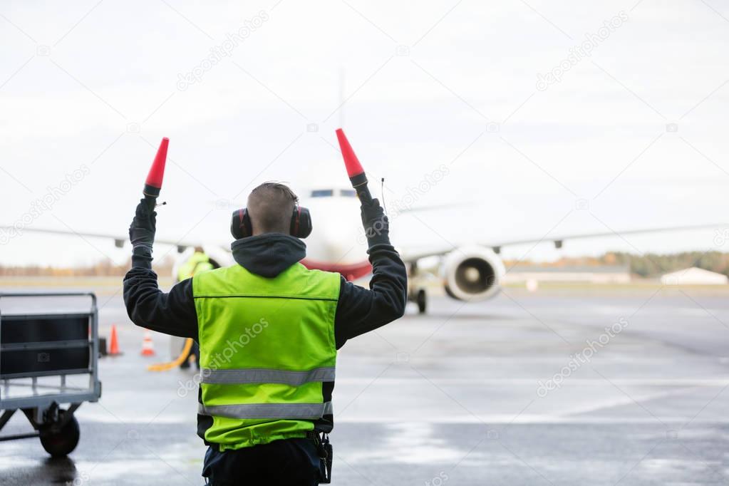 Ground Crew Signaling To Airplane