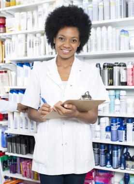 Pano karşı raflar tutan kadın eczacı