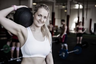 Sağlık topu ile egzersiz yaparken gülümseyen güzel kadın