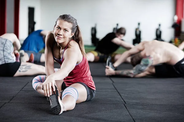 Žena cvičení s přáteli ve Fitness klubu — Stock fotografie
