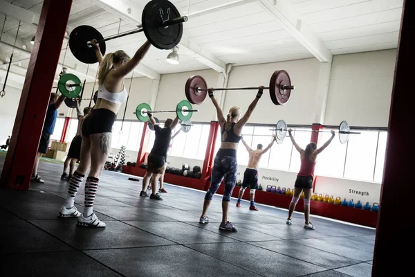 Kadın ve erkek sporcular barbell kaldırma — Stok fotoğraf