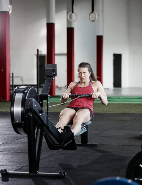 Ajuste mulher exercício no remo máquina — Fotografia de Stock