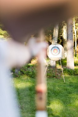 Hedef panosu ormandaki Aiming ok genç adam