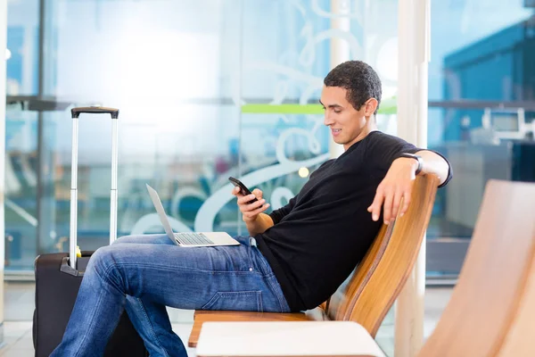 Человек с помощью смартфона в зоне ожидания аэропорта — стоковое фото