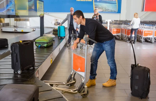 Hombre esperando por el equipaje de la cinta transportadora en el aeropuerto — Foto de Stock
